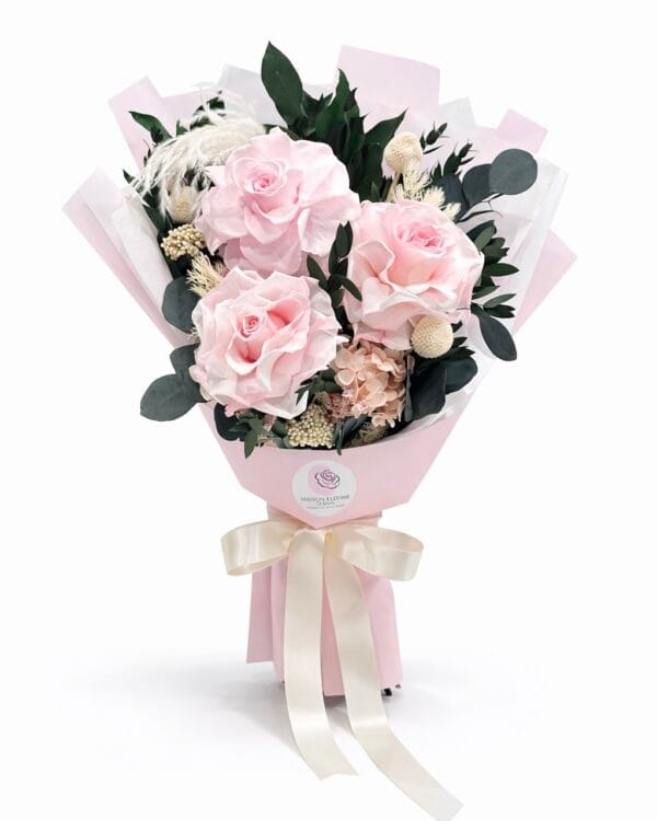 Blush Whisper preserved bouquet with soft pink roses, eucalyptus leaves, delicate filler flowers, and neutral greenery